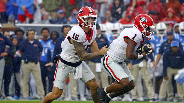 Nov 9, 2024; Oxford, Mississippi, USA; Georgia Bulldogs quarterback Carson Beck (15) hands the ball off to running back Trevor Etienne (1) during the first half against the Mississippi Rebels at Vaught-Hemingway Stadium. Mandatory Credit: Petre Thomas-Imagn Images