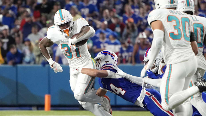 Buffalo Bills safety Cole Bishop (24) tackles Miami Dolphins running back Ollie Gordon II (31) in the fourth quarter at Highmark Stadium. Buffalo Bills safety Cole Bishop (24) tackles Miami Dolphins running back Ollie Gordon II (31) in the fourth quarter at Highmark Stadium.