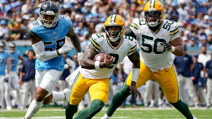 Green Bay Packers quarterback Malik Willis runs the ball past Tennessee Titans linebacker Harold Landry III.