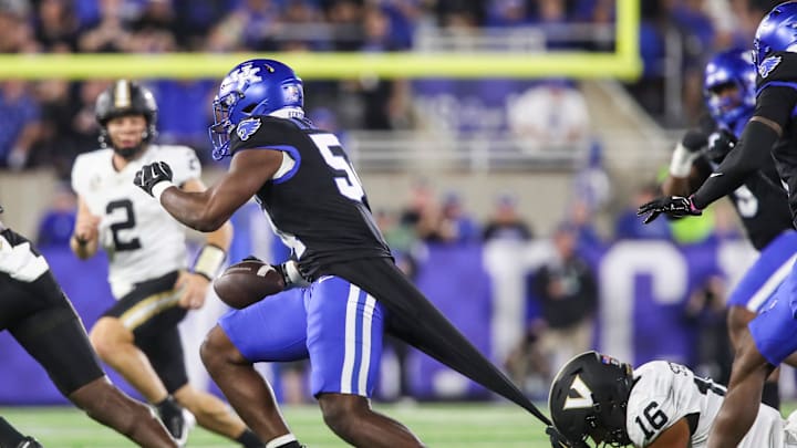 Linebacker D'Eryk Jackson (54) of the Kentucky Wildcats intercepts this pass in the first half as tight end Cole Spence (16) of the Vanderbilt Commodores tries to stop him with a grip on Jackson's shirt Saturday, Oct. 12, 2024 in Lexington, Ky.