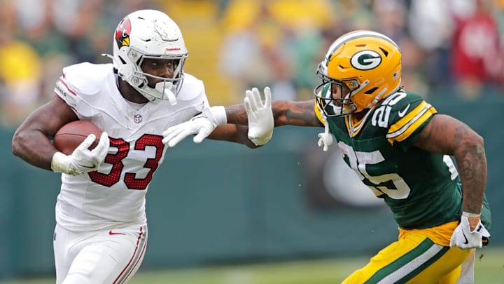 Arizona Cardinals running back Trey Benson (33) runs for a first down against Green Bay Packers cornerback Keisean Nixon (25) in the third quarter during their football game Sunday, October 13, 2024, at Lambeau Field in Green Bay, Wisconsin. Arizona Cardinals running back Trey Benson (33) runs for a first down against Green Bay Packers cornerback Keisean Nixon (25) in the third quarter during their football game Sunday, October 13, 2024, at Lambeau Field in Green Bay, Wisconsin.