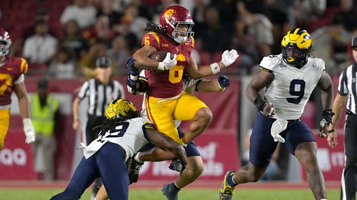 Oct 11, 2025; Los Angeles, California, USA;  USC Trojans wide receiver Makai Lemon (6) runs for a first down before he is stopped by Michigan Wolverines linebacker Jimmy Rolder (30), defensive back Rod Moore (19) and defensive end Cameron Brandt (9) in the second half at United Airlines Field at the Los Angeles Memorial Coliseum. Mandatory Credit: Jayne Kamin-Oncea-Imagn Images
