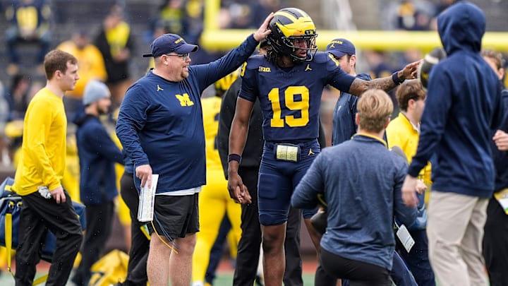 Michigan tight ends coach Steve Casula, left, talks to quarterback Bryce Underwood (19) 