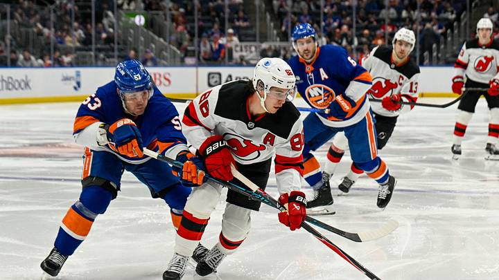 Jan 6, 2026; Elmont, New York, USA;  New York Islanders center Casey Cizikas (53) defends against New Jersey Devils center Jack Hughes (86) during the third period at UBS Arena. Mandatory Credit: Dennis Schneidler-Imagn Images