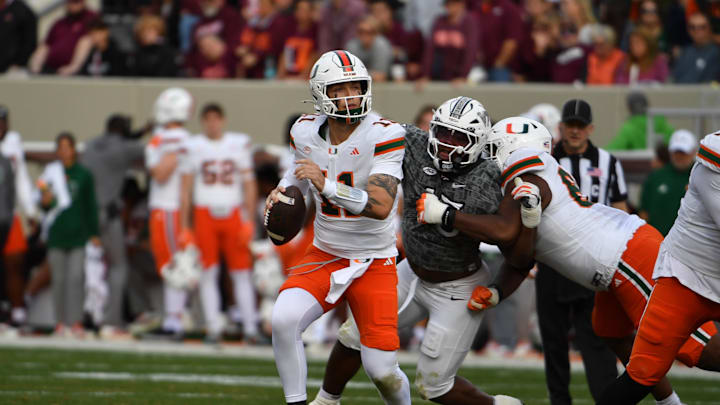 Nov 22, 2025; Blacksburg, Virginia, USA; Miami (FL) Hurricanes quarterback Carson Beck (11) looks to pass as Virginia Tech Hokies safety Brennan Johnson (15) applies pressure during the second quarter at Lane Stadium. Mandatory Credit: Brian Bishop-Imagn Images