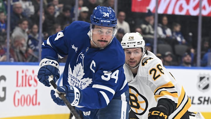Nov 8, 2025; Toronto, Ontario, CAN;  Toronto Maple Leafs forward Auston Matthews (34) pursues the puck ahead of Boston Bruins defenseman Andrew Peeke (26) in the first period at Scotiabank Arena. Mandatory Credit: Dan Hamilton-Imagn Images
