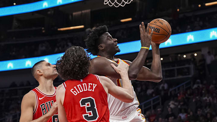 Nov 9, 2024; Atlanta, Georgia, USA; Atlanta Hawks center Clint Capela (15) shoots behind Chicago Bulls center Nikola Vucevic (9) and guard Josh Giddey (3) during the first half at State Farm Arena. Mandatory Credit: Dale Zanine-Imagn Images