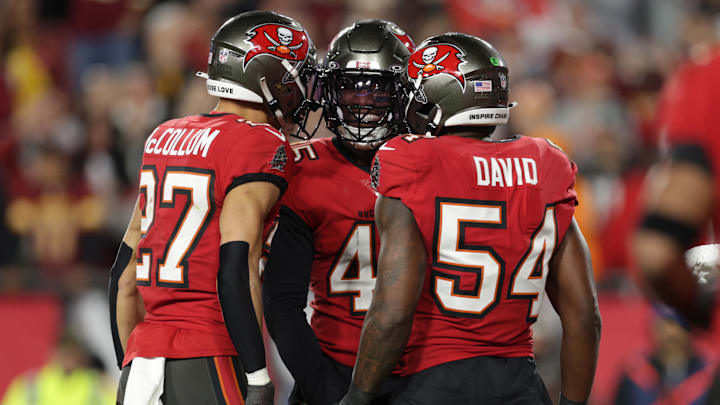 Jan 12, 2025; Tampa, Florida, USA; Tampa Bay Buccaneers linebacker Deion Jones (45) celebrates with cornerback Zyon McCollum (27) and linebacker Lavonte David (54) after a play during the fourth quarter of a NFC wild card playoff against the Washington Commanders at Raymond James Stadium. Mandatory Credit: Nathan Ray Seebeck-Imagn Images