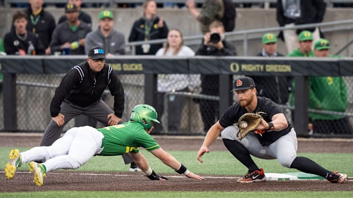 Oregon infielder Ryan Cooney dives safely back to first under cover from Oregon State infielder Jacob Krieg as the Oregon Ducks host the Oregon State Beavers on April 25, 2025, at PK Park in Eugene.
