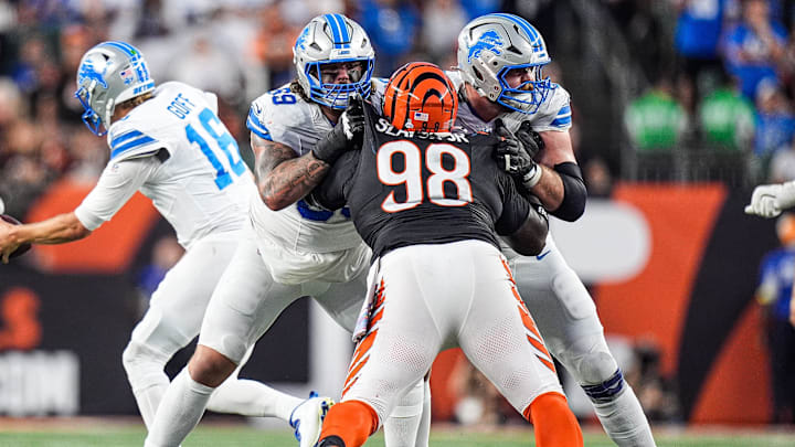 Detroit Lions guard Tate Ratledge (69), left, and center Graham Glasgow (60) block Cincinnati Bengals defensive tackle T.J. Slaton Jr. (98) during the second half at Paycor Stadium in Cincinnati on Sunday, Oct. 5, 2025.