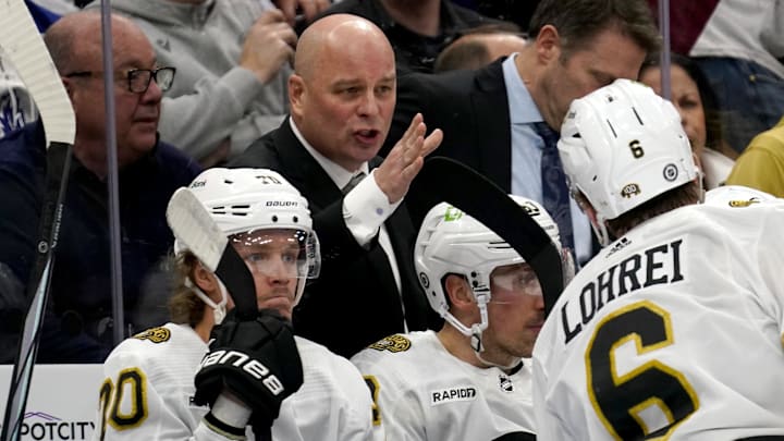 Mar 4, 2024; Toronto, Ontario, CAN; Boston Bruins head coach Jim Montgomery talks to defenseman Mason Lohrei (6) during a break in the action against the Toronto Maple Leafs during the second period at Scotiabank Arena. Mandatory Credit: John E. Sokolowski-Imagn Images