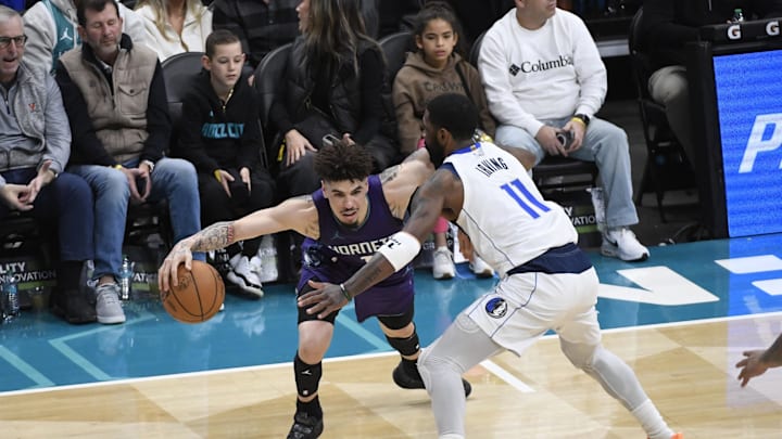 Jan 20, 2025; Charlotte, North Carolina, USA;  Charlotte Hornets guard LaMelo Ball (1) drives past Dallas Mavericks guard Kyrie Irving (11) during the first second at the Spectrum Center. Mandatory Credit: Sam Sharpe-Imagn Images