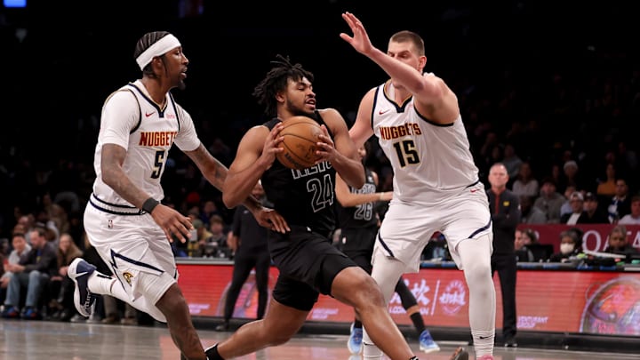 Dec 22, 2023; Brooklyn, New York, USA; Brooklyn Nets guard Cam Thomas (24) drives to the basket against Denver Nuggets guard Kentavious Caldwell-Pope (5) and center Nikola Jokic (15) during the third quarter at Barclays Center. Mandatory Credit: Brad Penner-Imagn Images Dec 22, 2023; Brooklyn, New York, USA; Brooklyn Nets guard Cam Thomas (24) drives to the basket against Denver Nuggets guard Kentavious Caldwell-Pope (5) and center Nikola Jokic (15) during the third quarter at Barclays Center. Mandatory Credit: Brad Penner-Imagn Images