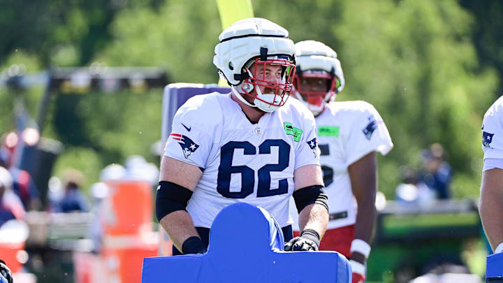 New England Patriots guard Bill Murray (62) works with the tackling sled.
