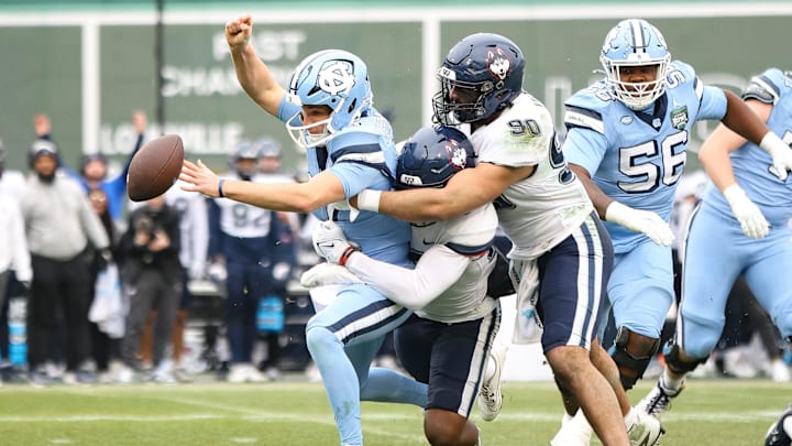 UConn's Pryce Yates, right, combines on the sack of North Carolina quarterback Michael Merdinger during the third annual Wasabi Fenway Bowl at Fenway Park on Saturday, Dec. 28, 2024.