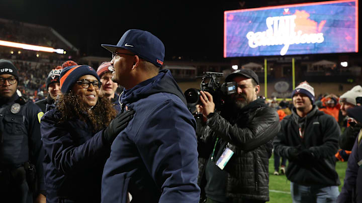Nov 29, 2025; Charlottesville, Virginia, USA; Virginia Cavaliers head coach Tony Elliott (R) celebrates with Virginia director of athletics Carla Williams (L) on the field after the Cavaliers' game against the Virginia Tech Hokies at Scott Stadium. Mandatory Credit: Geoff Burke-Imagn Images Nov 29, 2025; Charlottesville, Virginia, USA; Virginia Cavaliers head coach Tony Elliott (R) celebrates with Virginia director of athletics Carla Williams (L) on the field after the Cavaliers' game against the Virginia Tech Hokies at Scott Stadium. Mandatory Credit: Geoff Burke-Imagn Images