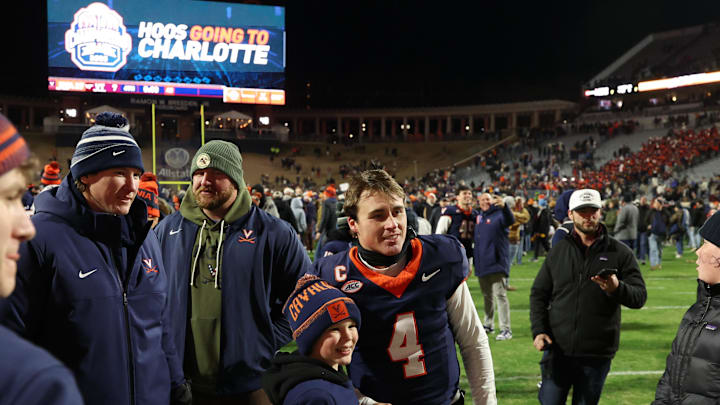 Nov 29, 2025; Charlottesville, Virginia, USA; Virginia Cavaliers quarterback Chandler Morris (4) poses for a picture with a young fan on the field after the Cavaliers' game against the Virginia Tech Hokies at Scott Stadium. Mandatory Credit: Geoff Burke-Imagn Images