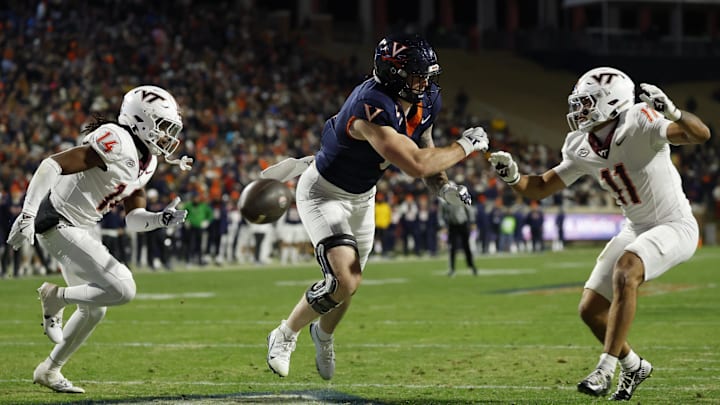 Nov 29, 2025; Charlottesville, Virginia, USA; Virginia Cavaliers tight end Sage Ennis (0) attempts to catch a pass in the end zone as Virginia Tech Hokies safety Sheldon Robinson (14) and Hokies safety Tyson Flowers (11) defend in the third quarter at Scott Stadium. Mandatory Credit: Geoff Burke-Imagn Images