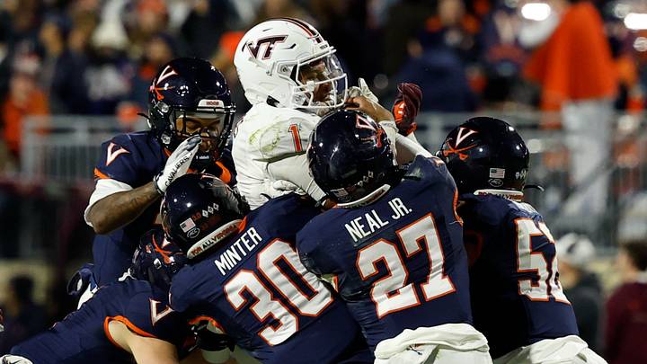 Nov 29, 2025; Charlottesville, Virginia, USA; Virginia Tech Hokies quarterback Kyron Drones (1) is tackled while running the ball on a fourth down by Virginia Cavaliers safety Ethan Minter (30) and Cavaliers safety Devin Neal (27) in the first quarter at Scott Stadium. Mandatory Credit: Geoff Burke-Imagn Images Nov 29, 2025; Charlottesville, Virginia, USA; Virginia Tech Hokies quarterback Kyron Drones (1) is tackled while running the ball on a fourth down by Virginia Cavaliers safety Ethan Minter (30) and Cavaliers safety Devin Neal (27) in the first quarter at Scott Stadium. Mandatory Credit: Geoff Burke-Imagn Images