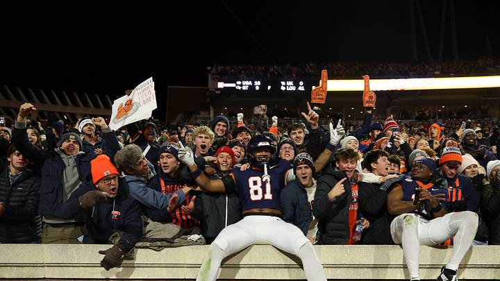 Nov 29, 2025; Charlottesville, Virginia, USA; Virginia Cavaliers tight end Tekai Kirby (81) leaps onto the wall in the student sections to celebrate with students and fans after their game against the Virginia Tech Hokies at Scott Stadium. Mandatory Credit: Geoff Burke-Imagn Images