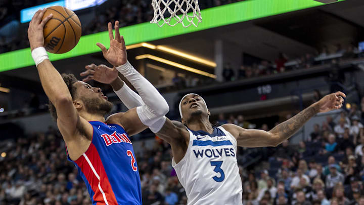 Mar 27, 2024; Minneapolis, Minnesota, USA; Detroit Pistons guard Cade Cunningham (2) drives to the basket and attempts to shoot the ball past Minnesota Timberwolves forward Jaden McDaniels (3) in the second half at Target Center. Mandatory Credit: Jesse Johnson-Imagn Images