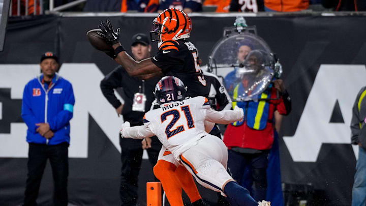 Cincinnati Bengals wide receiver Tee Higgins (5) catches a pass ahead of Denver Broncos cornerback Riley Moss (21) for the game-winning touchdown in overtime of the NFL Week 17 game between the Cincinnati Bengals and the Denver Broncos at Paycor Stadium in downtown Cincinnati on Saturday, Dec. 28, 2024. The Bengals took a 30-24 win in overtime to remain in the post season chase.