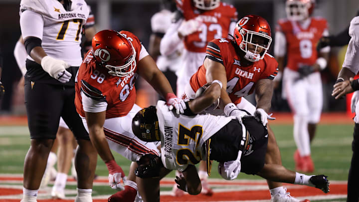 Oct 11, 2025; Salt Lake City, Utah, USA; Arizona State Sun Devils running back Demarius Robinson (23) is thrown down by Utah Utes defensive tackle Dallas Vakalahi (98) and defensive tackle Sione Motuapuaka (44) during the fourth quarter at Rice-Eccles Stadium. Mandatory Credit: Rob Gray-Imagn Images
