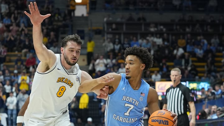 Jan 17, 2026; Berkeley, California, USA; North Carolina Tar Heels guard Seth Trimble (7) dribbles against California Golden Bears center Milos Ilic (8) during the first half at Haas Pavilion. Mandatory Credit: Darren Yamashita-Imagn Images