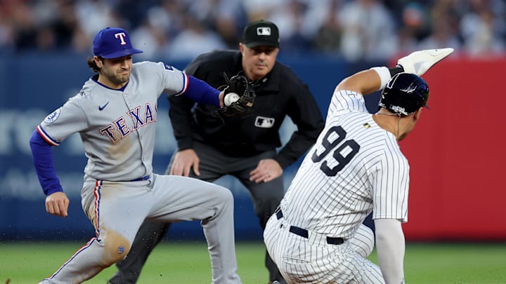 May 20, 2025; Bronx, New York, USA; New York Yankees right fielder Aaron Judge (99) steals second base ahead of a tag by Texas Rangers shortstop Josh Smith (8) during the fourth inning at Yankee Stadium. Mandatory Credit: Brad Penner-Imagn Images