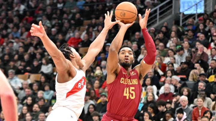 Jan 1, 2024; Toronto, Ontario, CAN; Cleveland Cavaliers guard Donovan Mitchell (45) shoots the ball over Toronto Raptors forward Scottie Barnes (4) in the first half at Scotiabank Arena. Mandatory Credit: Dan Hamilton-USA TODAY Sports