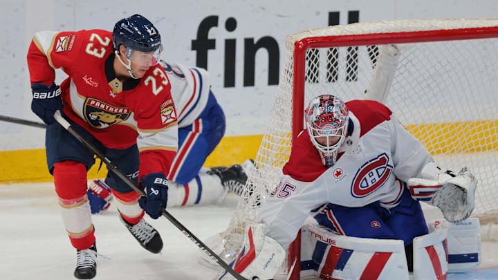 Mar 30, 2025; Sunrise, Florida, USA; Florida Panthers center Carter Verhaeghe (23) moves the puck in front of Montreal Canadiens goaltender Sam Montembeault (35) during the third period at Amerant Bank Arena. Mandatory Credit: Sam Navarro-Imagn Images