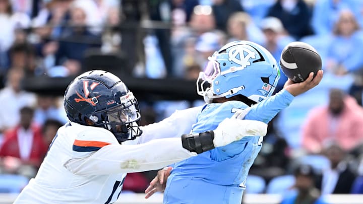 Oct 25, 2025; Chapel Hill, North Carolina, USA; North Carolina Tar Heels quarterback Gio Lopez (7) passes the ball as Virginia Cavaliers defensive end Mitchell Melton (17) pressures in the third quarter at Kenan Stadium. Mandatory Credit: Bob Donnan-Imagn Images