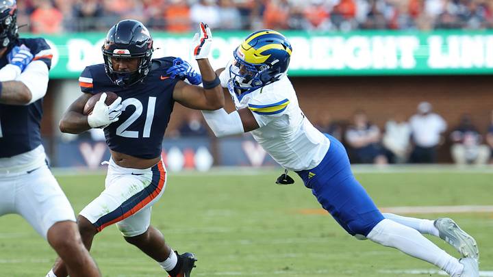 Sep 26, 2026; Charlottesville, Virginia, USA; Virginia Cavaliers running back Jekail Middlebrook (21) carries the ball as Delaware Blue Hens defensive back Kt Seay (7) attempts a tackle during the first half at Scott Stadium. Mandatory Credit: Geoff Burke-Imagn Images Sep 26, 2026; Charlottesville, Virginia, USA; Virginia Cavaliers running back Jekail Middlebrook (21) carries the ball as Delaware Blue Hens defensive back Kt Seay (7) attempts a tackle during the first half at Scott Stadium. Mandatory Credit: Geoff Burke-Imagn Images