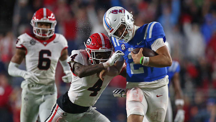 Nov 9, 2024; Oxford, Mississippi, USA; Mississippi Rebels quarterback Jaxson Dart (2) runs the ball as Georgia Bulldogs defensive back KJ Bolden (4) makes the tackle during the second half at Vaught-Hemingway Stadium. Mandatory Credit: Petre Thomas-Imagn Images Nov 9, 2024; Oxford, Mississippi, USA; Mississippi Rebels quarterback Jaxson Dart (2) runs the ball as Georgia Bulldogs defensive back KJ Bolden (4) makes the tackle during the second half at Vaught-Hemingway Stadium. Mandatory Credit: Petre Thomas-Imagn Images
