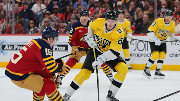 Feb 4, 2026; Sunrise, Florida, USA; Boston Bruins defenseman Mason Lohrei (6) moves the puck against Florida Panthers center Anton Lundell (15) during the second period at Amerant Bank Arena. Mandatory Credit: Sam Navarro-Imagn Images