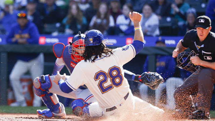 Seattle Mariners third baseman Eugenio Suarez (28) slides home to score a run against Texas Rangers catcher Jonah Heim (28) during the fourth inning at T-Mobile Park in 2023. 