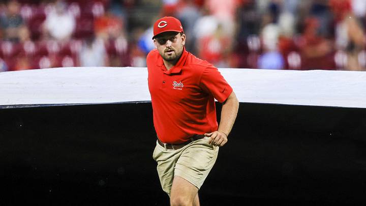 Aug 12, 2025; Cincinnati, Ohio, USA; A member of the grounds crew pulls the tarp over the field during a rain delay in the seventh inning in the game between the Philadelphia Phillies and the Cincinnati Reds at Great American Ball Park. Mandatory Credit: Katie Stratman-Imagn Images