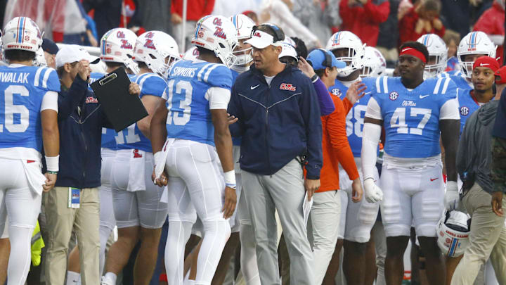 Nov 9, 2024; Oxford, Mississippi, USA; Mississippi Rebels head coach Lane Kiffin talks with quarterback Austin Simmons (13) after a touchdown during the first half against the Georgia Bulldogs at Vaught-Hemingway Stadium. Mandatory Credit: Petre Thomas-Imagn Images