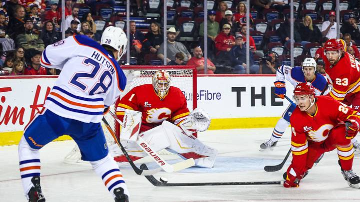 Sep 21, 2025; Calgary, Alberta, CAN; Calgary Flames goaltender Devin Cooley (1) guards his net against Edmonton Oilers right wing Quinn Hutson (28) during the first period at Scotiabank Saddledome. Mandatory Credit: Sergei Belski-Imagn Images