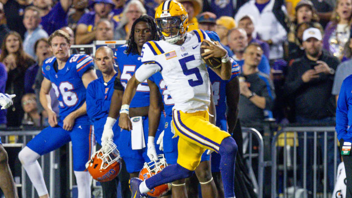 LSU Tigers quarterback Jayden Daniels runs the ball against the Florida Gators defense.
