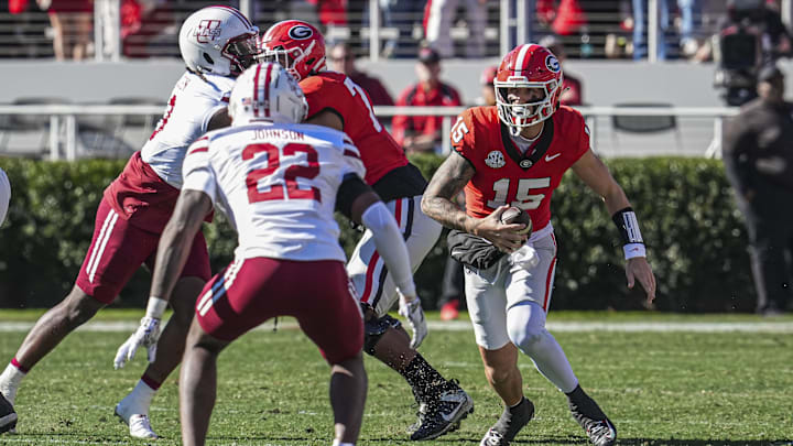 Nov 23, 2024; Athens, Georgia, USA; Georgia Bulldogs quarterback Carson Beck (15) runs against Massachusetts Minutemen linebacker Gerrell Johnson (22) during the first quarter at Sanford Stadium. Mandatory Credit: Dale Zanine-Imagn Images