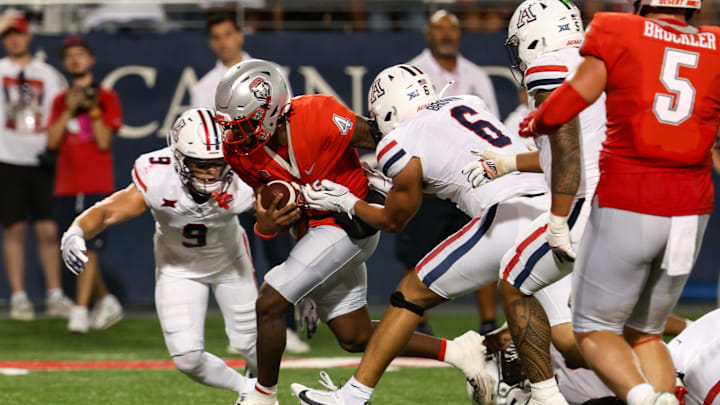 Aug 31, 2024; Tucson, Arizona, USA; New Mexico quarterback Devon Dampier (4) runs ball for a touch while Arizona Wildcats defensive back Gunner Maldonado (9) and Arizona Wildcats linebacker Taye Brown (6) try to tackle him during second quarter at Arizona Stadium. Mandatory Credit: Aryanna Frank-Imagn Images