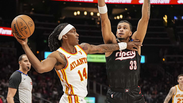 Apr 1, 2025; Atlanta, Georgia, USA; Atlanta Hawks guard Terance Mann (14) passes against Portland Trail Blazers forward Toumani Camara (33) during the first half at State Farm Arena. Mandatory Credit: Dale Zanine-Imagn Images