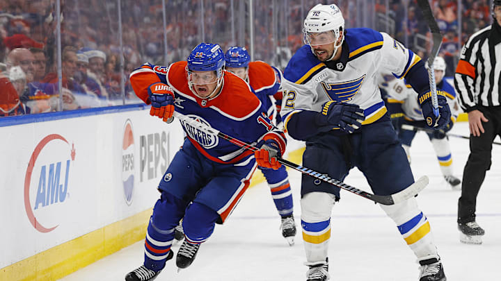 Dec 7, 2024; Edmonton, Alberta, CAN; Edmonton Oilers forward Mattias Janmark (13) and St. Louis Blues defensemen Justin Faulk (72) chase a loose puck during the third period at Rogers Place. Mandatory Credit: Perry Nelson-Imagn Images
