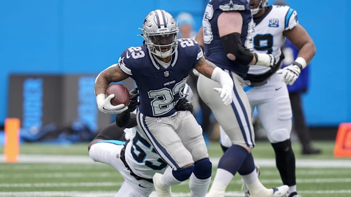 Dec 15, 2024; Charlotte, North Carolina, USA; Dallas Cowboys running back Rico Dowdle (23) runs out of a tackle by Carolina Panthers linebacker Claudin Cherelus (53) during the first quarter at Bank of America Stadium. Mandatory Credit: Jim Dedmon-Imagn Images