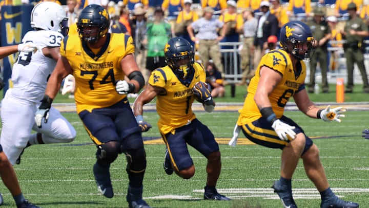 West Virginia University running back Jahiem White busting through the line of scrimmage against Penn State. 