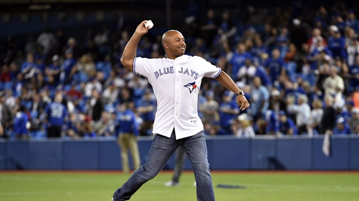 Former Toronto Blue Jays player Vernon Wells throws a first pitch wearing a white jersey. Former Toronto Blue Jays player Vernon Wells throws a first pitch wearing a white jersey.