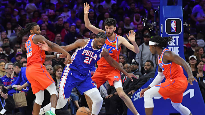 Apr 2, 2024; Philadelphia, Pennsylvania, USA; Philadelphia 76ers center Joel Embiid (21) battles for the ball with Oklahoma City Thunder guard Cason Wallace (22), forward Chet Holmgren (7) and guard Luguentz Dort (5) during the third quarter at Wells Fargo Center. Mandatory Credit: Eric Hartline-Imagn Images