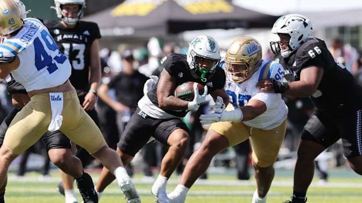 Aug 31, 2024; Honolulu, Hawaii, USA; UCLA Bruins defensive lineman Sitiveni Havili Kaufusi (95) tries to pull down Hawaii Rainbow Warriors running back Cam Barfield (9) during the second quarter of an NCAA college football game at the Clarence T.C. Ching Athletics Complex. Mandatory Credit: Marco Garcia-USA TODAY Sports