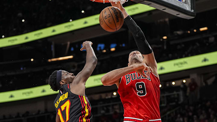 Dec 21, 2025; Atlanta, Georgia, USA; Chicago Bulls center Nikola Vucevic (9) dunks over Atlanta Hawks forward Onyeka Okongwu (17) during the second half at State Farm Arena. Mandatory Credit: Dale Zanine-Imagn Images